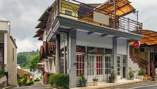 A two-story building with a balcony, large windows, and potted plants. - Hotel O Villa Papada (Batu)