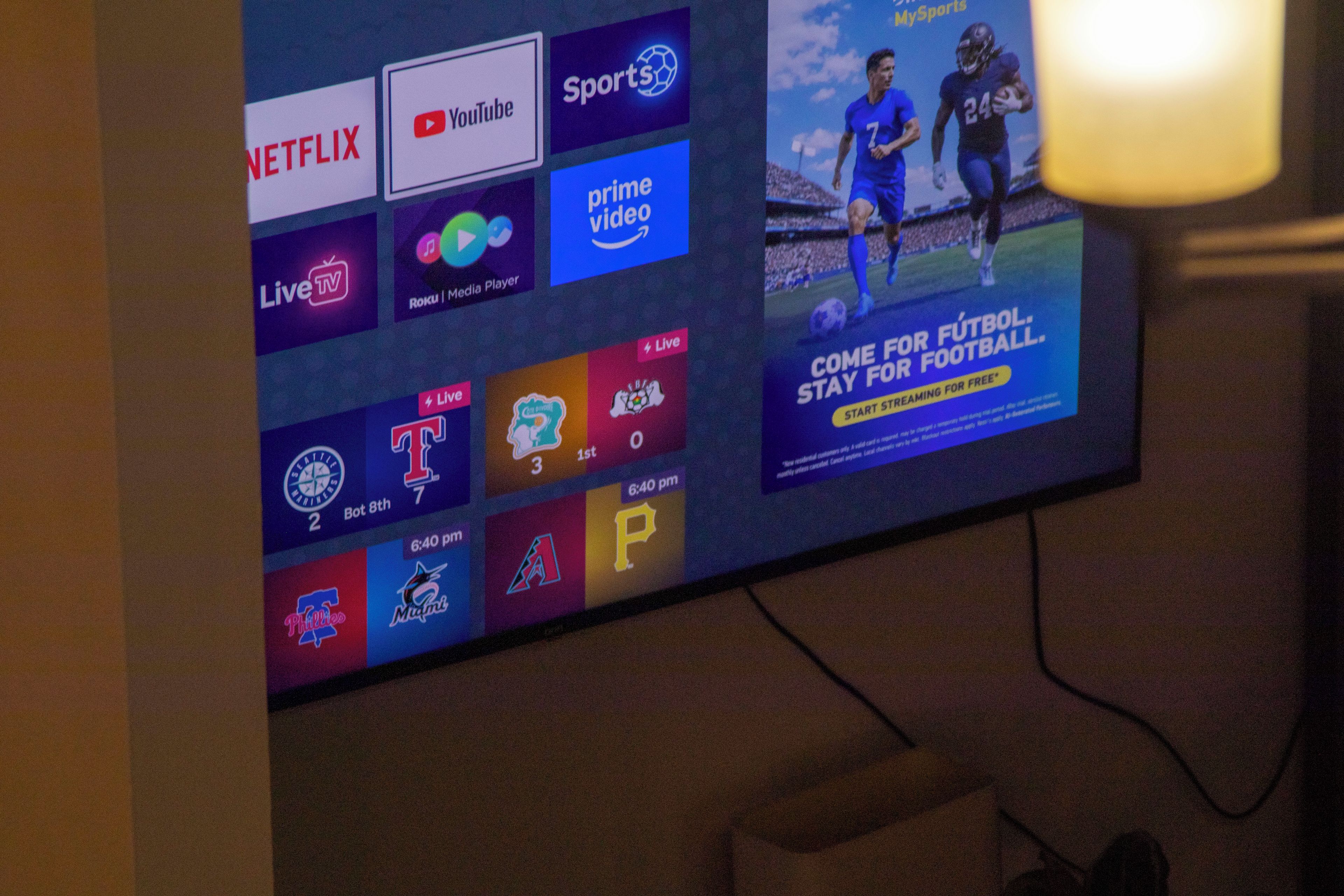 Una pantalla de televisión mostrando varios logotipos de servicios de streaming y un anuncio deportivo.