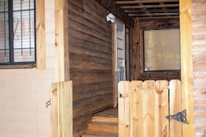 A wooden staircase leading to a door with a window above it.