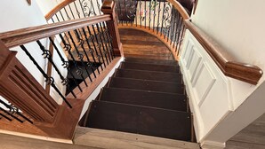 A wooden staircase with black railings and a dark floor. - Cheerful cabin, tucked away, for nature lovers. (Decatur)