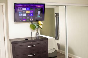 A television mounted on a wall displaying various streaming services.