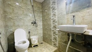 A bathroom with a toilet, shower, and sink. - Abodes Elegant Hills (Dehradun)