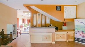 A reception area with a counter, a staircase, and a wall-mounted clock. - Hotel O Istana Griya 2 Hotel (Surakarta)
