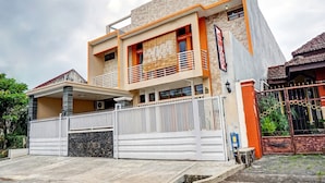 A modern two-story house with a balcony, a gated driveway, and a visible address sign. - Hotel O Avisha Guest House Syariah (Malang)