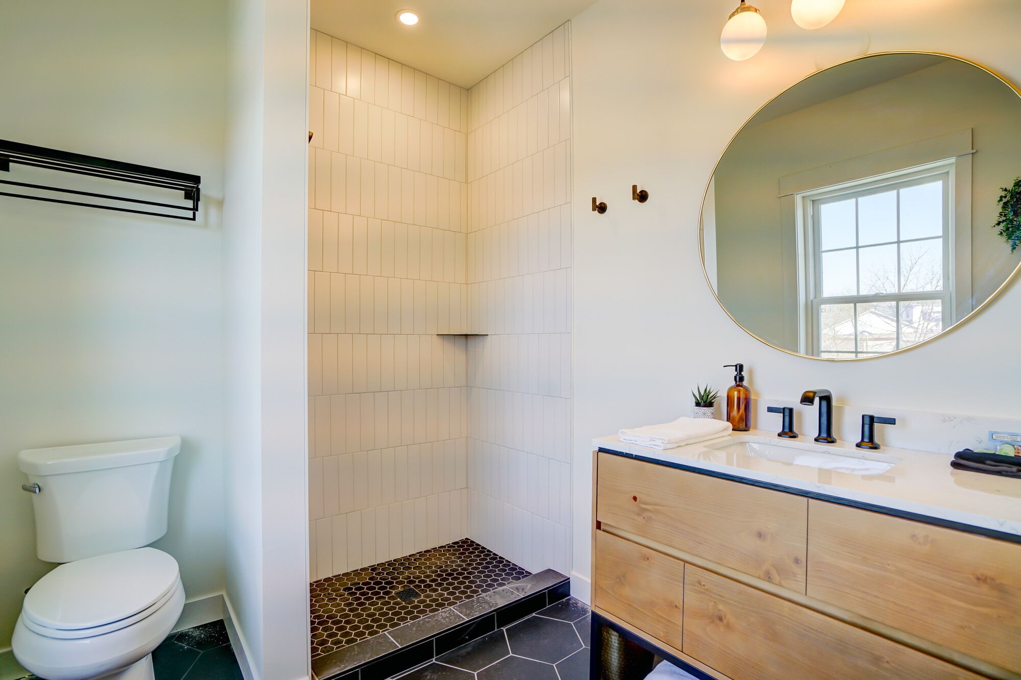 Un baño moderno con inodoro, ducha y tocador.