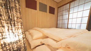 A room with a bed, wooden walls, and a shoji screen. - Asakusa, Tokyo Sky Tree (墨田区)