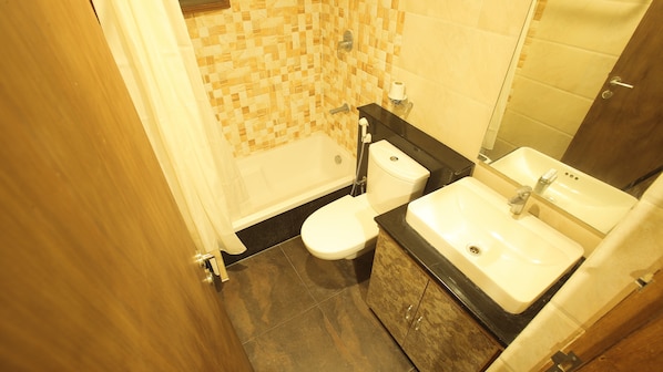A bathroom with a bathtub, toilet, and sink. - Hotel Vijayetha (Nagercoil)
