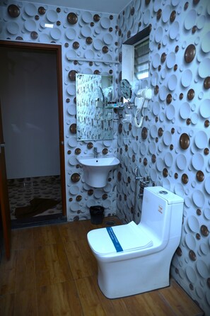 Un baño con inodoro, lavamanos y espejo.