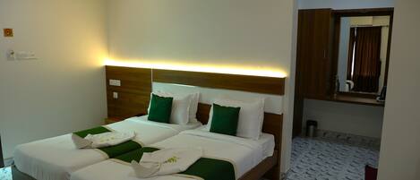 Een hotelkamer met een tweepersoonsbed, een hoofdeinde met geïntegreerde verlichting, een spiegel en een vloer met een patroon.