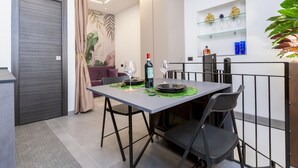 Un comedor moderno con una mesa lista para dos personas, una botella de vino y una copa.