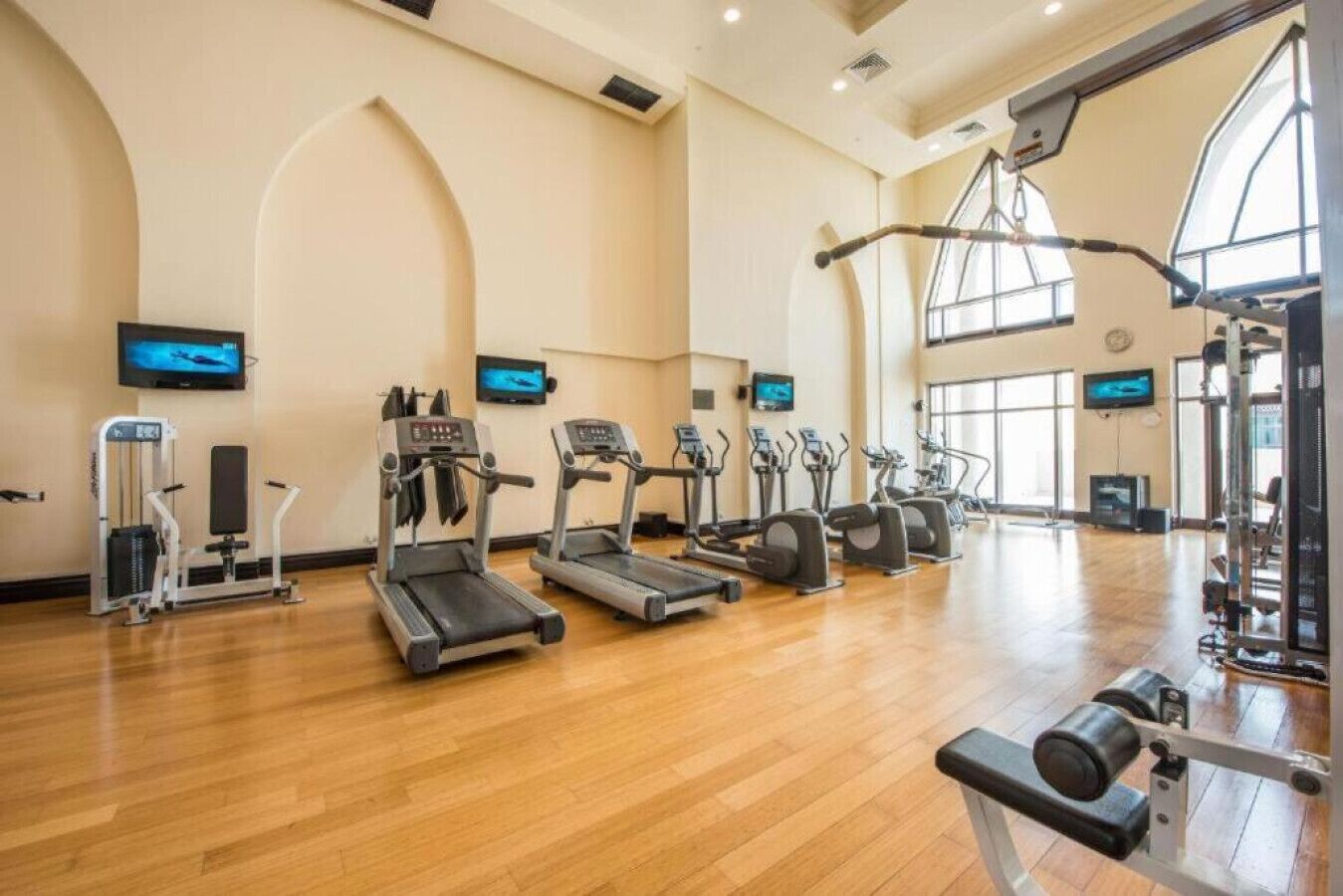 Una palestra con tapis roulant, macchinari ellittici e attrezzature per pesi.