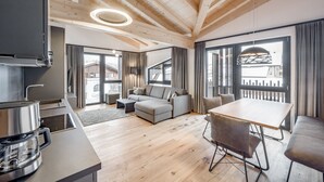 A modern living room with a sofa, a dining table, and a coffee maker.