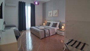 A modern bedroom with a bed, bedside tables, a desk, and a chair. - Costa Sicula (Avola)