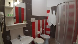 A bathroom with a sink, toilet, bidet, and a shower area. - Costa Sicula (Avola)