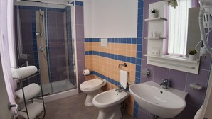 A bathroom with a shower, two toilets, a sink, and a mirror. - Costa Sicula (Avola)