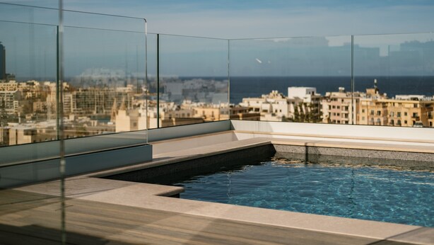 A rooftop infinity pool with a city view. - The Sliema Suites (Sliema)