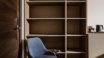A modern room with a built-in wooden shelving unit, a blue chair, and a coffee maker on a small table.