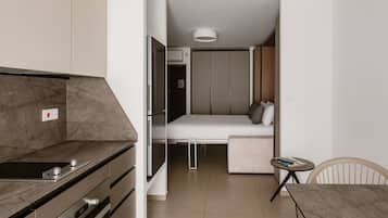 A compact living space with a kitchenette, a bed, and a small dining area.
