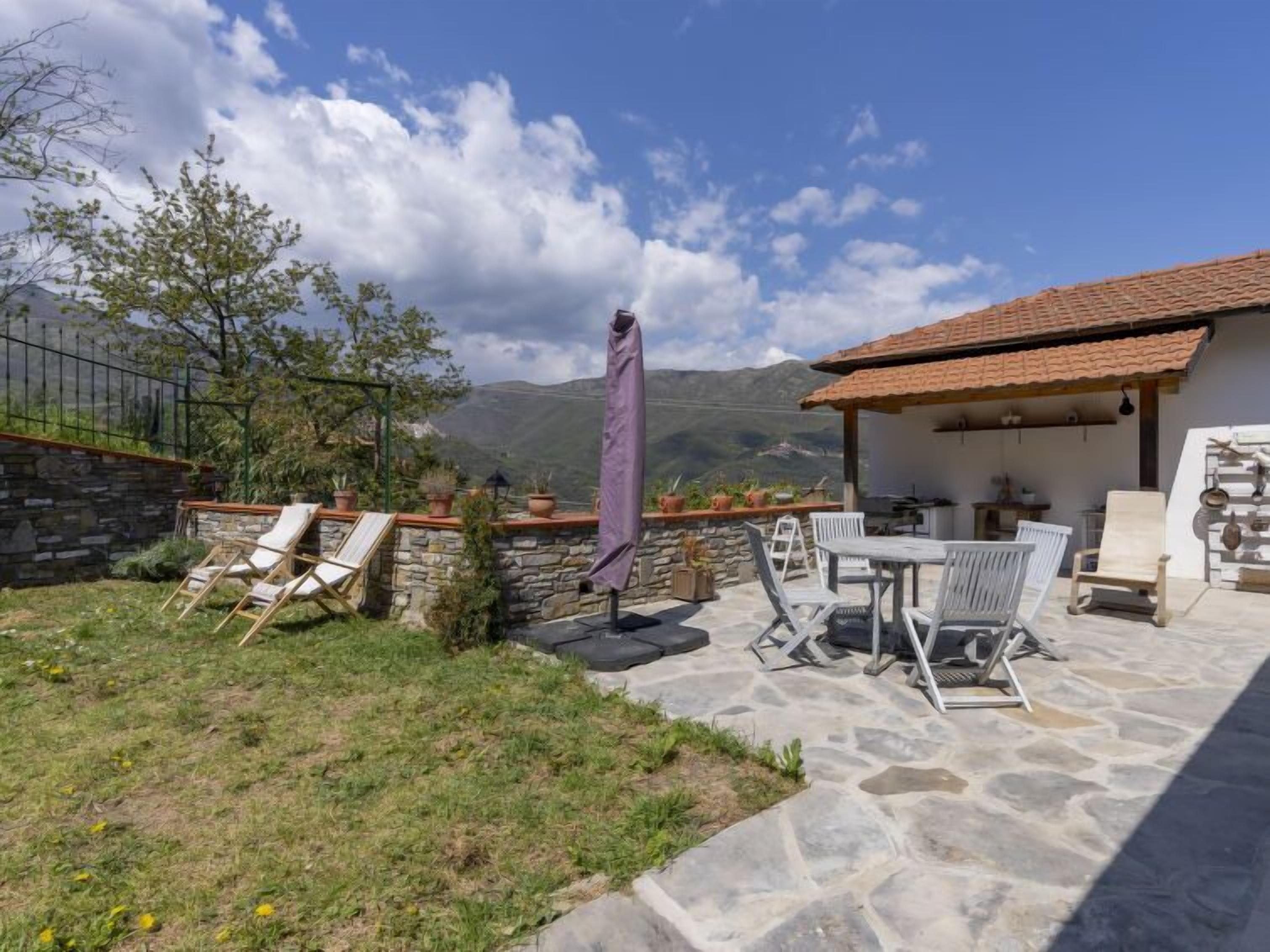 A patio with stone flooring, outdoor furniture, and a view of mountains.