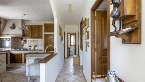 A spacious kitchen with wooden cabinets, a central island, and a dining area. - Vacation home Anna by Interhome (Ville San Pietro)
