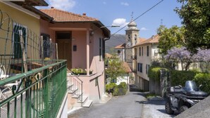 A narrow street with buildings on both sides, a bell tower, and a parked vehicle. - Vacation home Anna by Interhome (Ville San Pietro)