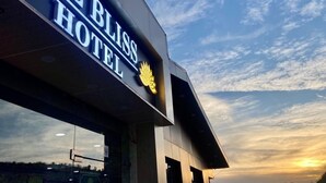 El exterior del Hotel Blind, con cielo despejado y un atardecer de fondo.