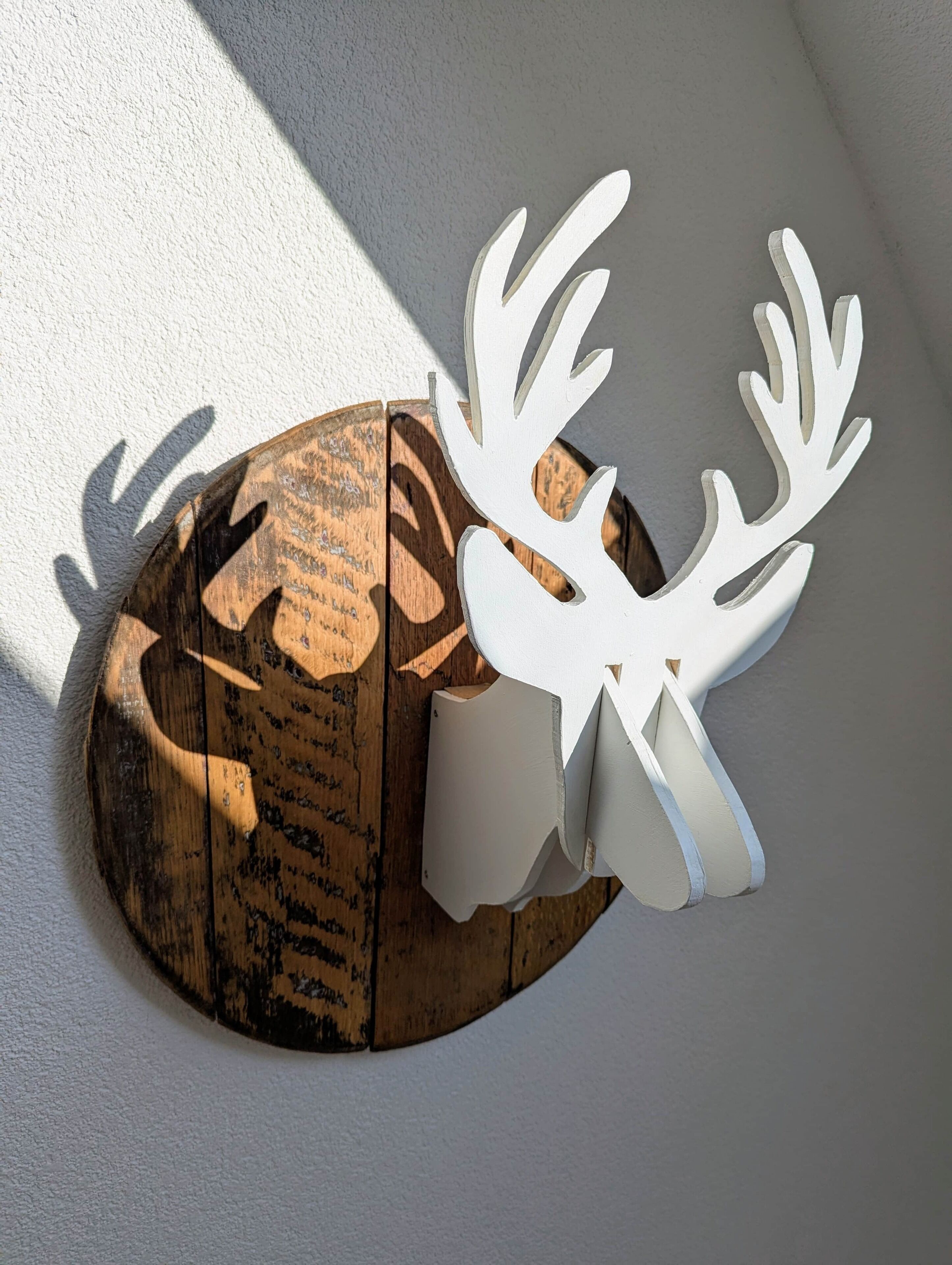Een houten decoratieve hertentête met hoorns.
