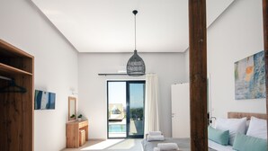 Une chambre d’hôtel moderne, équipée d’un lit, d’une armoire en bois, d’une salle de bain avec un miroir et offrant une vue sur l’extérieur.