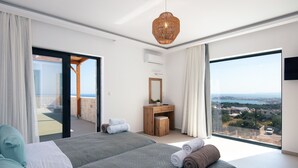Une chambre d’hôtel moderne avec deux lits, un bureau et un grand balcon offrant une vue dégagée.