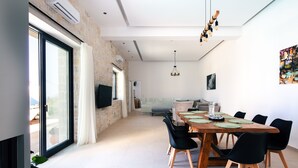 Un espace repas moderne avec une grande table, des chaises noires et un plafond en bois.