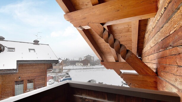 A wooden balcony with a view of snow-covered rooftops and buildings. - Apartment 'Chalet Li Palù Trilocale 4' with Mountain View, Balcony and Wi-Fi (Livigno)