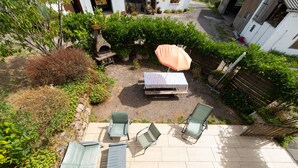 A patio area with a table, two chairs, and a bench.