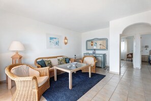 A living room with wicker furniture, a glass-top coffee table, and a blue rug. - Holiday Home 'Villa Verde Superior' with Sea View, Wi-Fi and Air Conditioning (dos pinos)