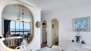 Zona pranzo con un tavolo rotondo, sedie e vista attraverso una finestra ad arco.