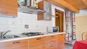 A kitchen with a stove, microwave, and wooden cabinets.