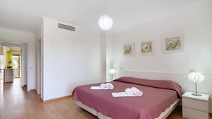 Un dormitorio con cama, mesitas de noche y una obra de arte en la pared.