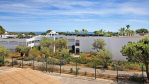 A coastal hotel with white buildings, palm trees, and a clear sky. - Apartment 'Yara Beach Apartments with Terrace' with Shared Pool, Wi-Fi and Air Conditioning (Albufeira)