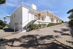 A modern building with a staircase leading to a balcony, a paved walkway, and a clear sky. - Apartment 'Yara Beach Apartments with Terrace' with Shared Pool, Wi-Fi and Air Conditioning (Albufeira)