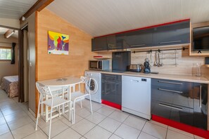 A modern kitchen with a dining area, a washing machine, and a microwave.