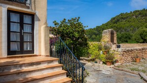 A stone staircase leading to a building with a window and a stone structure in the background. - Country House 'Son Favar Capdepera' with Private Pool, Private Terrace and Wi-Fi (Capdepera)