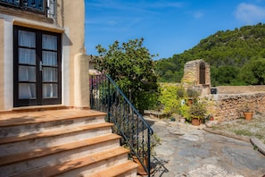 A stone staircase leading to a building with a window and a stone structure in the background. - Country House 'Son Favar Capdepera' with Private Pool, Private Terrace and Wi-Fi (Capdepera)