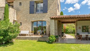A stone building with a balcony, outdoor seating, and a patio area. - Villa 'Les Terrasses De Gordes' with Private Pool, Private Terrace and Wi-Fi (Gordes)