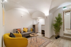 Um interior moderno com um sofá, uma poltrona amarela e uma pequena mesa de madeira.