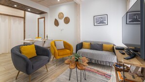Una sala moderna con sofá, sillones, una mesa de centro y un comedor con mesa y sillas.