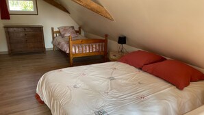 A bedroom with a wooden bed, a nightstand, a dresser, and a window. - Charming Gîte near Le Mans - Peaceful, Independent with Private Parking, Fully Equipped, High-Speed WiFi (Roëzé-sur-Sarthe)