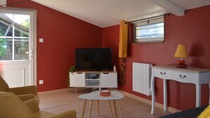 A living room with a television, a small table, and a lamp. - Charming Gîte near Le Mans - Peaceful, Independent with Private Parking, Fully Equipped, High-Speed WiFi (Roëzé-sur-Sarthe)