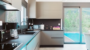 Een moderne keuken met een Bosch koffiezetapparaat, een waterkoker en een broodbak.