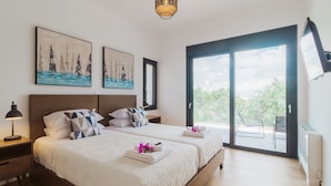 Een hotelkamer met twee bedden, een groot raam en kunst aan de muur.
