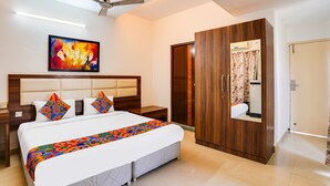 A hotel room with a large bed, a wardrobe, a ceiling fan, and a painting on the wall. - FabHotel VJR Electronic City (Bengaluru)