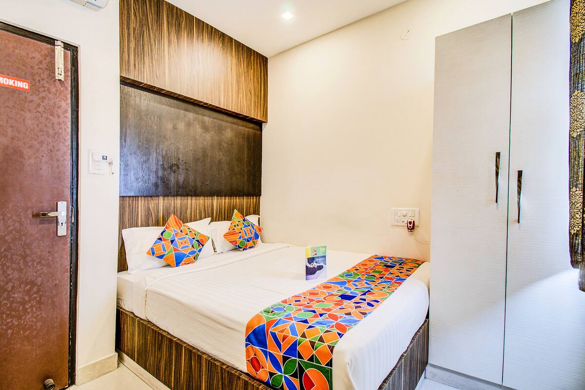 Una habitación de hotel con cama, armario y puerta con letrero de 'No Fumar'.